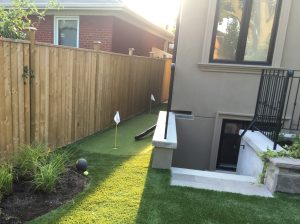 narrow synthetic golf green at side yard